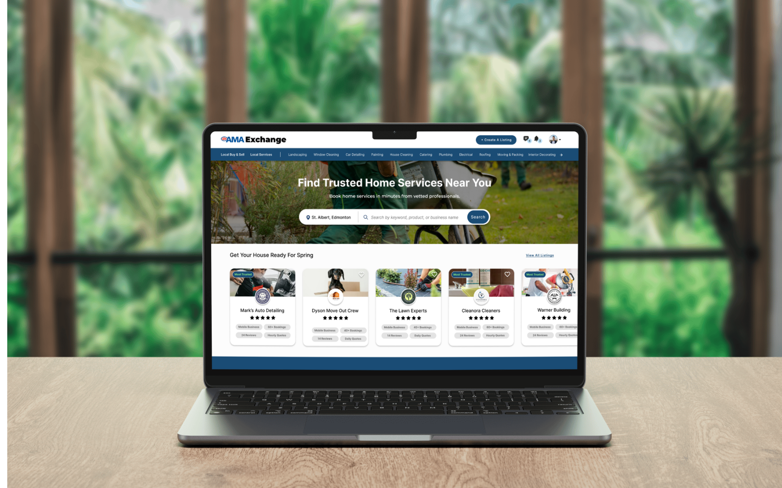 AMA Exchange home page mockup, displayed on a laptop on a wooden desk